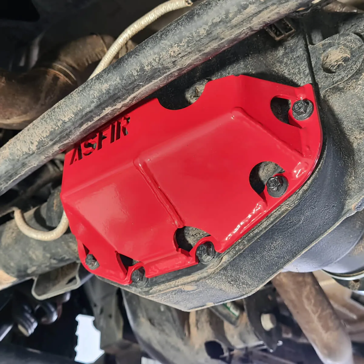 Red ASFIR differential skid plate installed on a Jeep axle