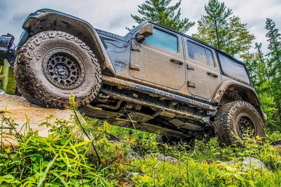 Jeep Wrangler Unlimited climbing a ledge in the forest